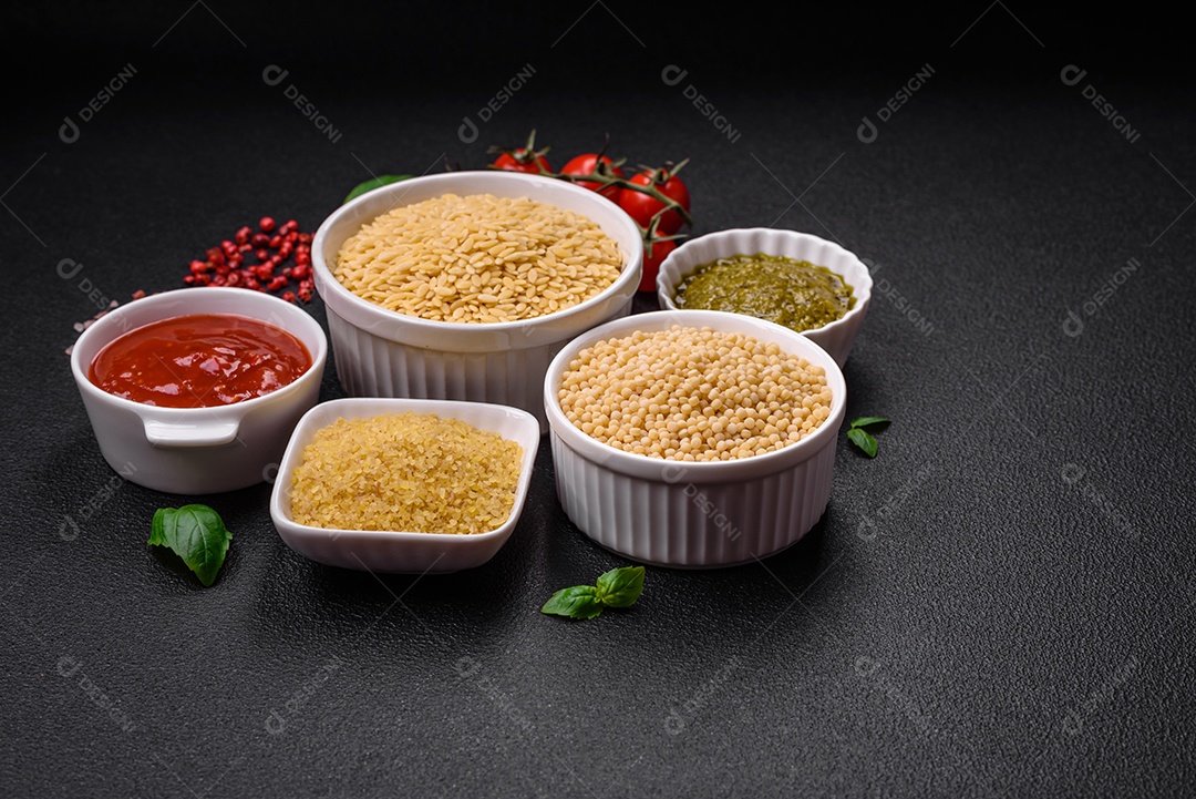 Massa orzo crua integral como ingrediente de um prato delicioso. Prato da cozinha mediterrânea