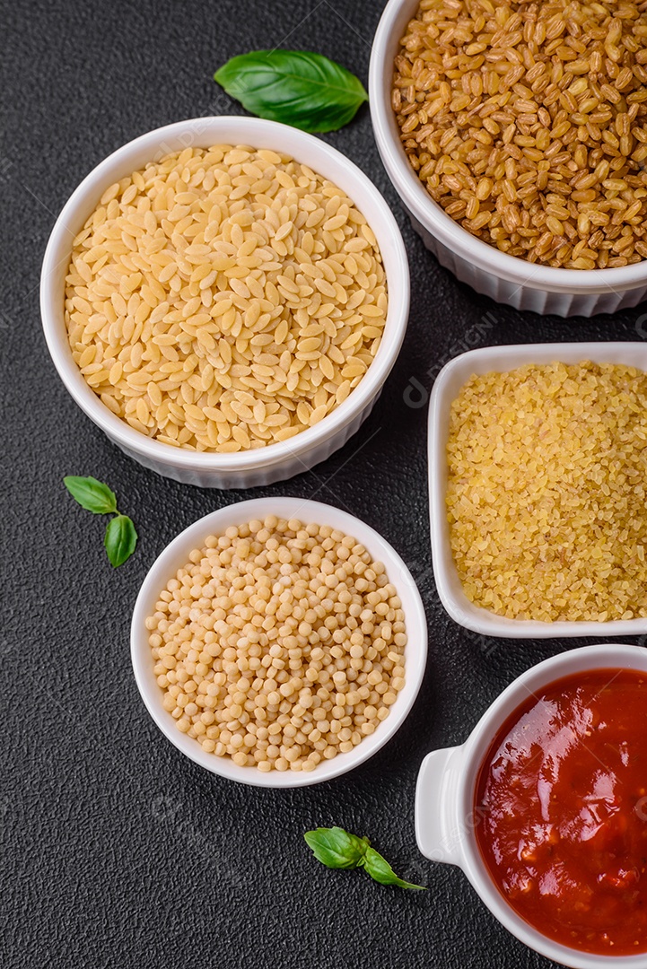 Massa orzo crua integral como ingrediente de um prato delicioso. Prato da cozinha mediterrânea