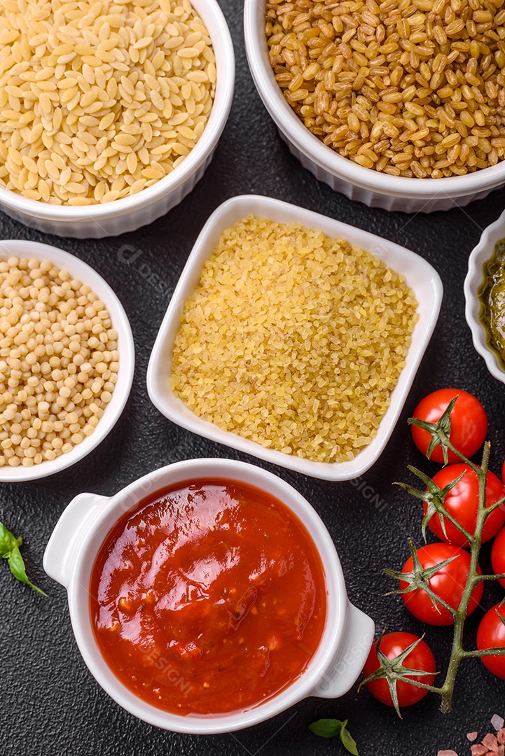 Massa orzo crua integral como ingrediente de um prato delicioso. Prato da cozinha mediterrânea