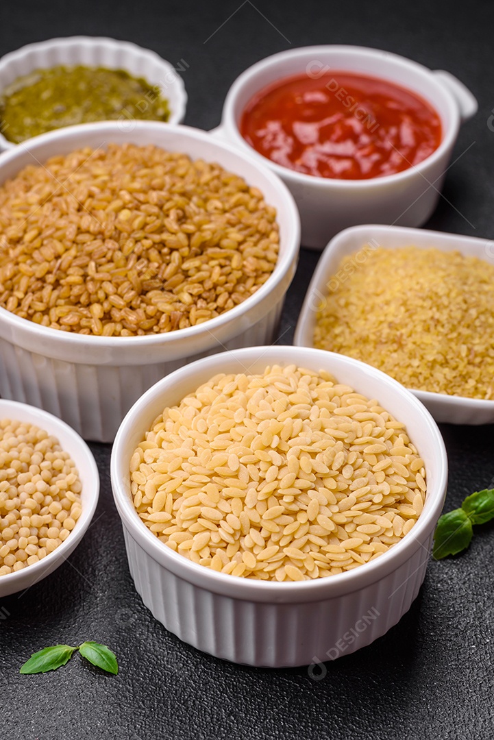 Massa orzo crua integral como ingrediente de um prato delicioso. Prato da cozinha mediterrânea