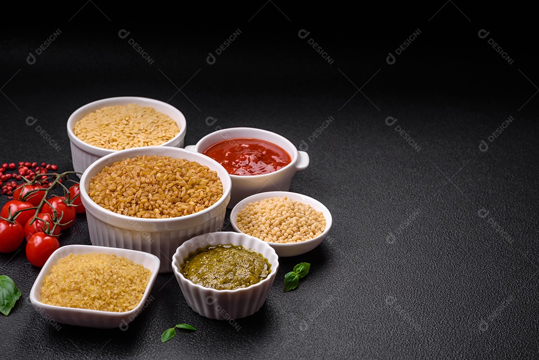 Massa orzo crua integral como ingrediente de um prato delicioso. Prato da cozinha mediterrânea