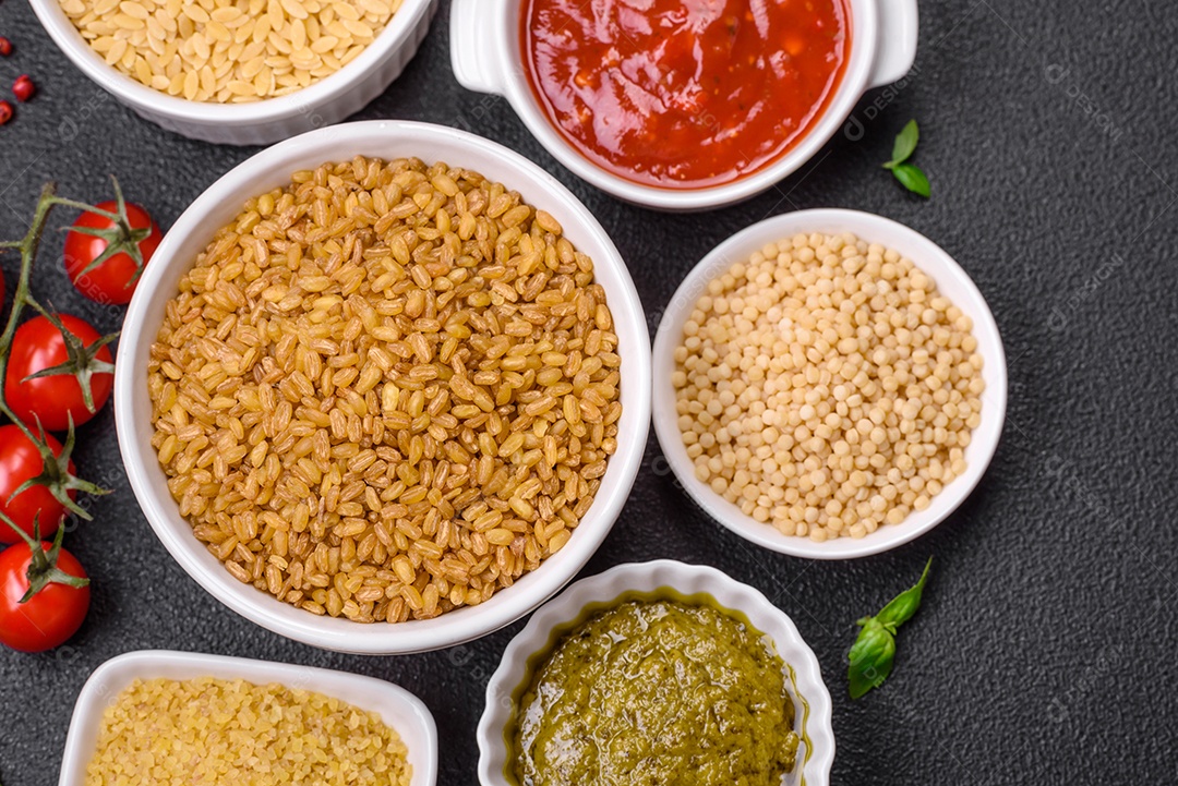 Massa orzo crua integral como ingrediente de um prato delicioso. Prato da cozinha mediterrânea