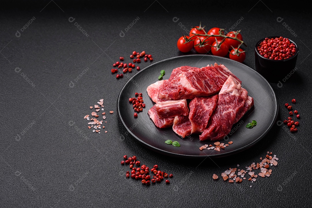 Carne de peru crua em forma de fatias com sal, especiarias e ervas sobre um fundo escuro de concreto