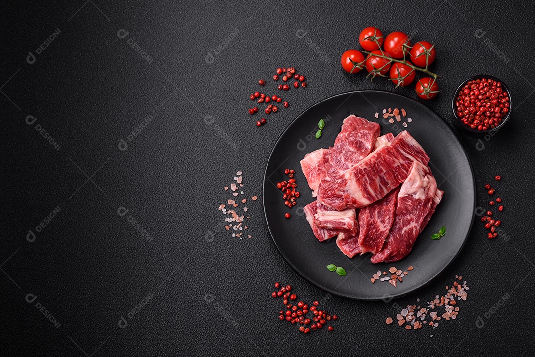 Carne de peru crua em forma de fatias com sal, especiarias e ervas sobre um fundo escuro de concreto