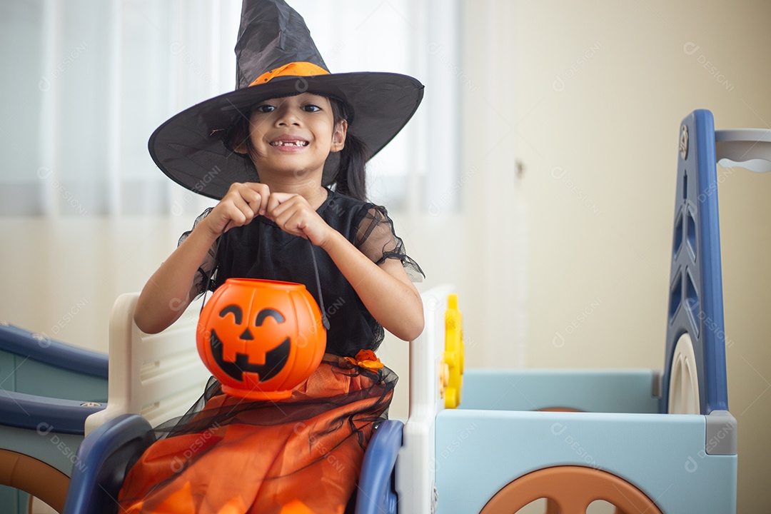 Menina asiática feliz em uma fantasia de bruxa para o Halloween.