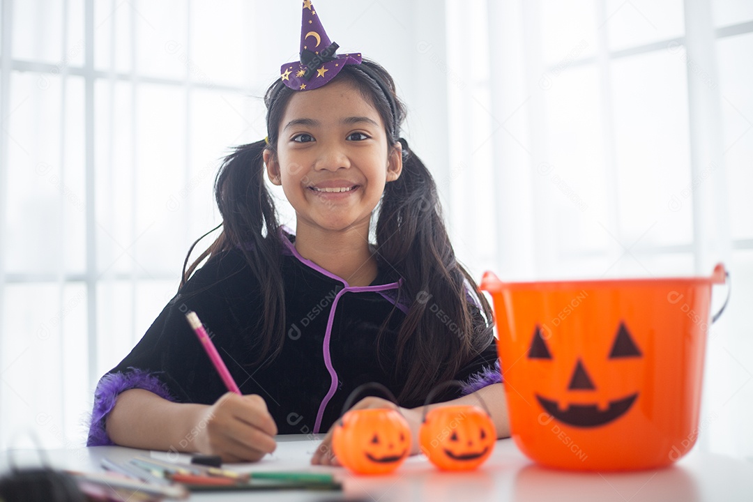 Menina asiática feliz em uma fantasia de bruxa para o Halloween.