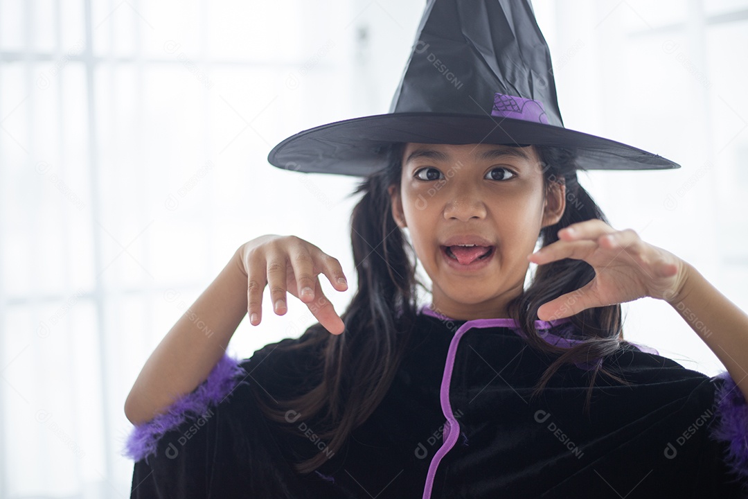 Menina asiática feliz em uma fantasia de bruxa para o Halloween.