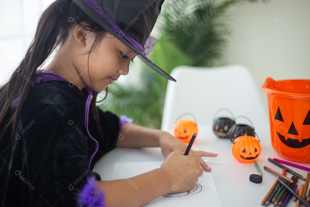 Menina asiática feliz em uma fantasia de bruxa para o Halloween.