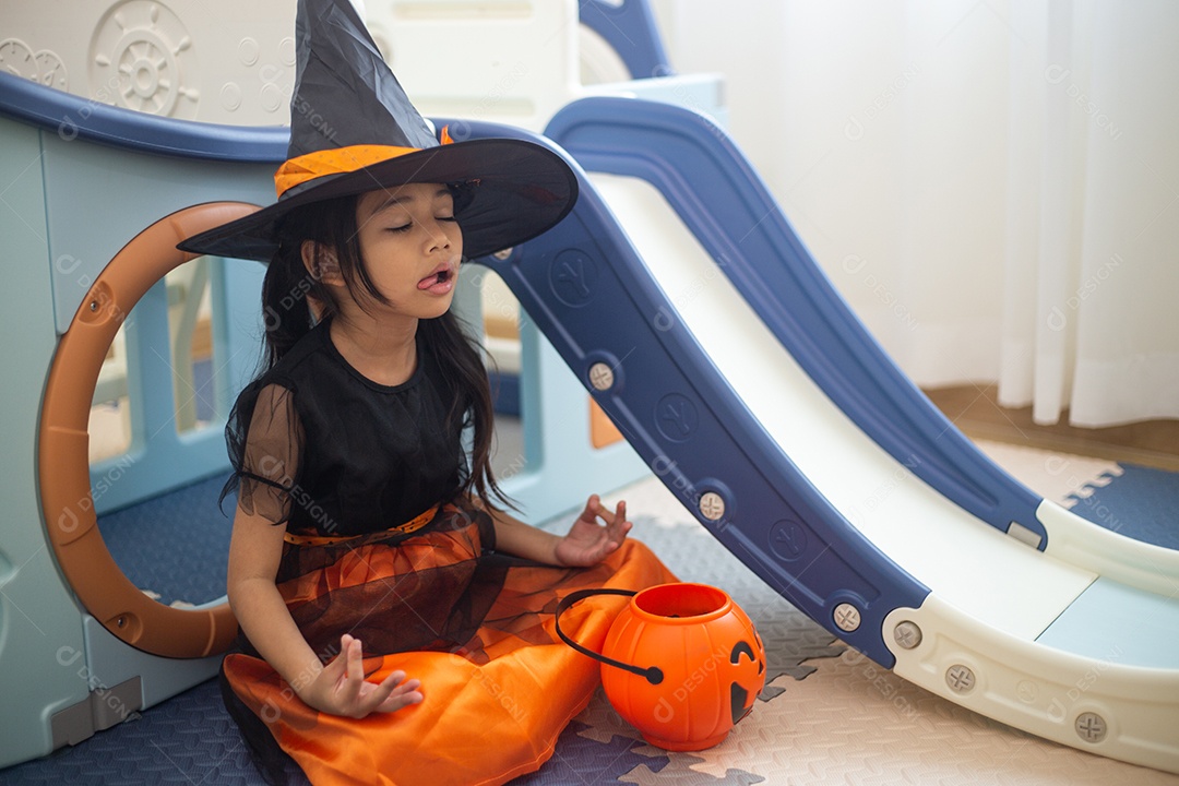 Menina asiática feliz em uma fantasia de bruxa para o Halloween.