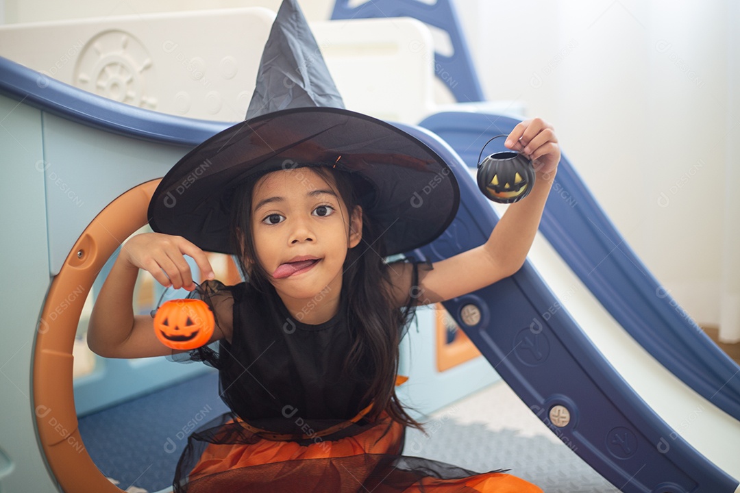 Menina asiática feliz em uma fantasia de bruxa para o Halloween.