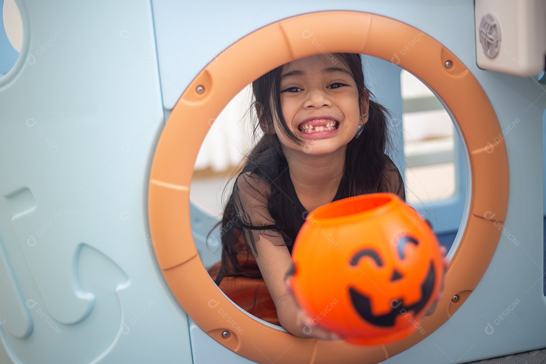 Menina asiática feliz em uma fantasia de bruxa para o Halloween.