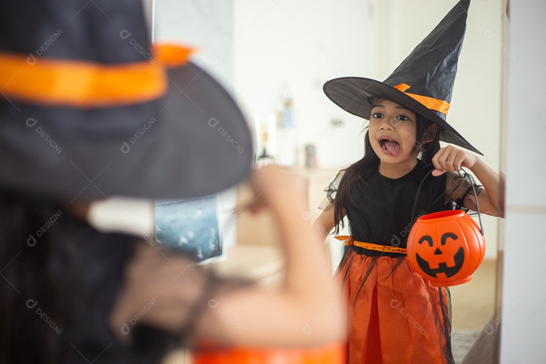 Menina asiática feliz em uma fantasia de bruxa para o Halloween.