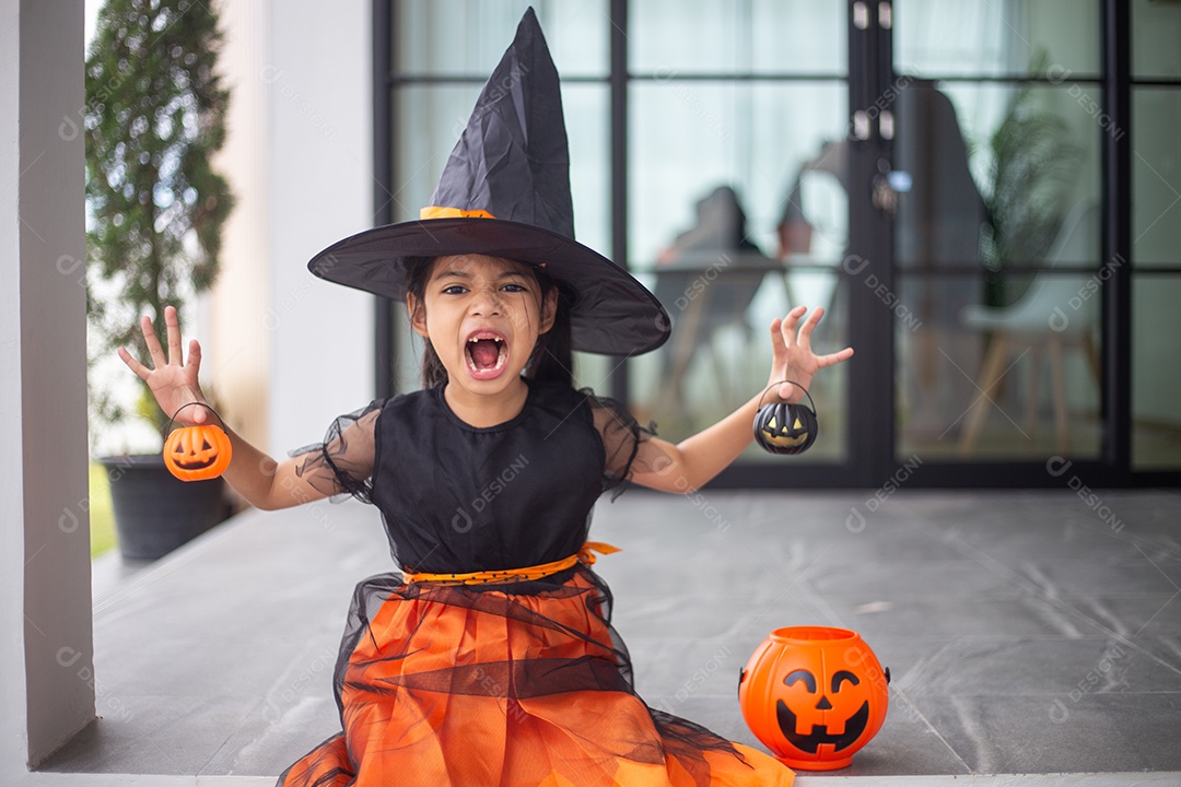 Menina asiática feliz em uma fantasia de bruxa para o Halloween.