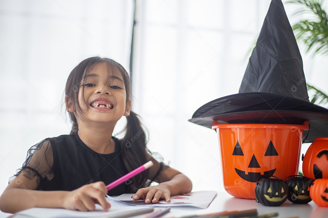 Menina asiática feliz em uma fantasia de bruxa para o Halloween.