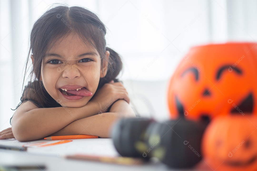 Menina asiática feliz em uma fantasia de bruxa para o Halloween.