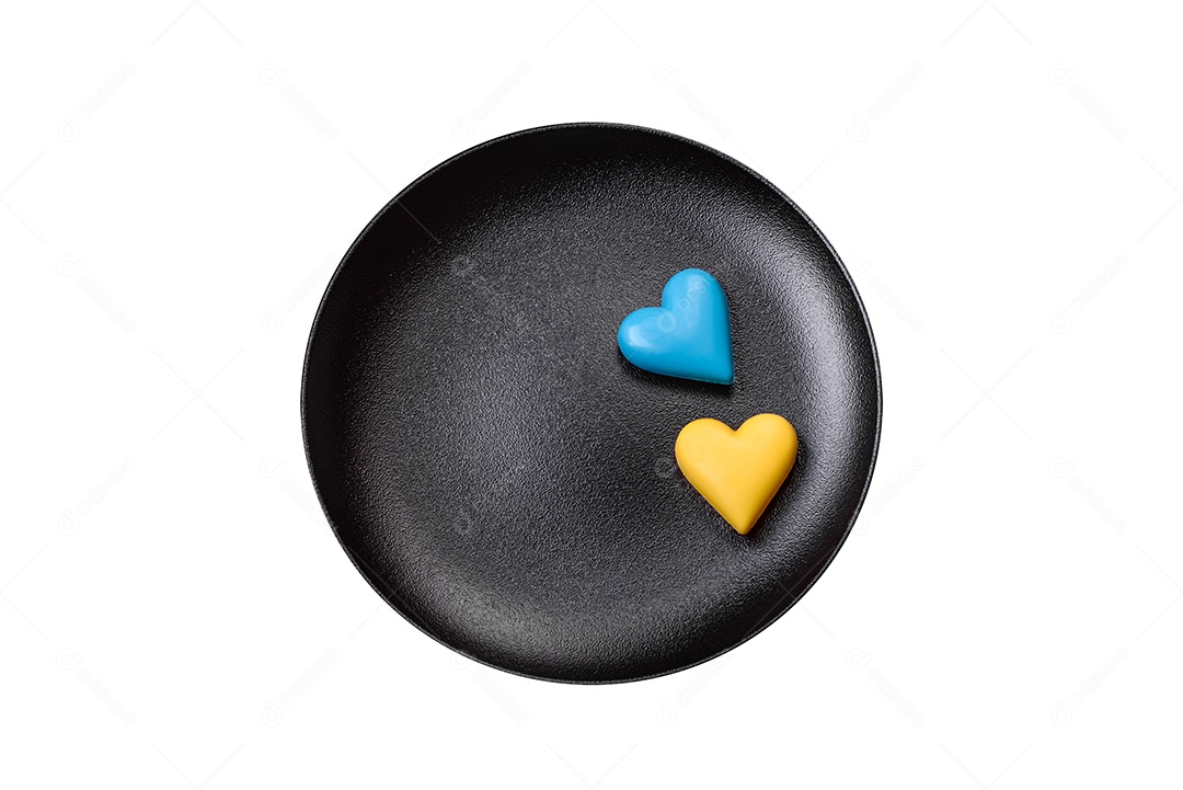 Corações de chocolate nas cores da bandeira ucraniana num prato de cerâmica preto. Dia dos Namorados em cores ucranianas