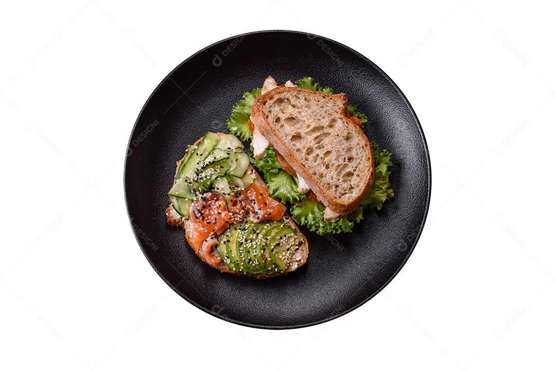 Sanduíche fresco e saboroso com salmão, abacate e sementes de gergelim e linho sobre um fundo escuro de concreto