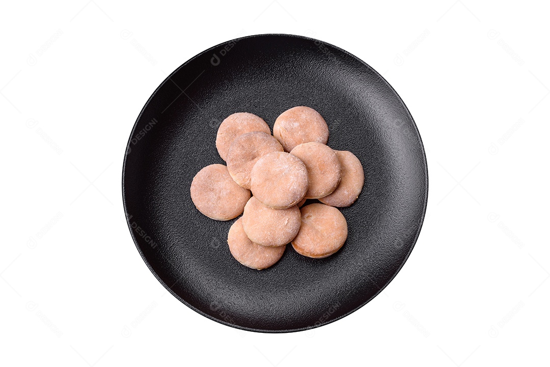 Deliciosos bolinhos de fubá frescos ou biscoitos em uma placa de cerâmica preta sobre um fundo escuro de concreto