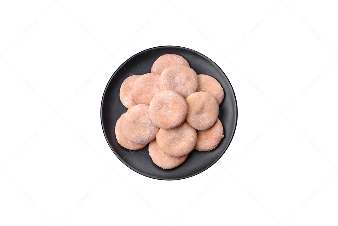 Deliciosos bolinhos de fubá frescos ou biscoitos em uma placa de cerâmica preta sobre um fundo escuro de concreto