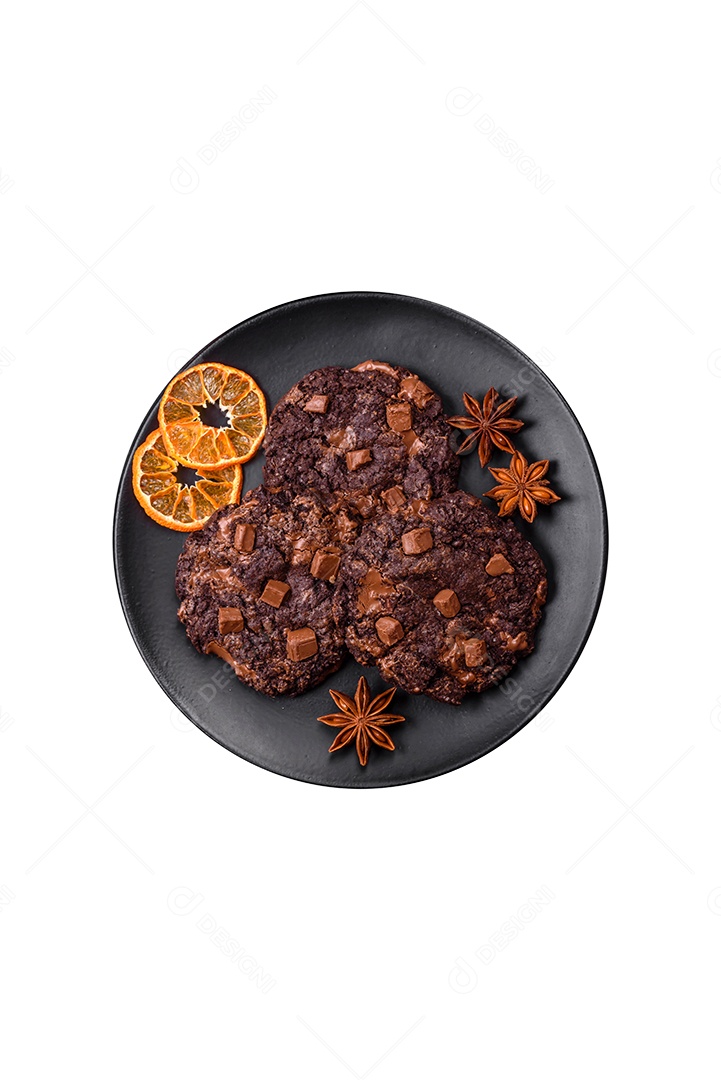 Deliciosos biscoitos redondos de aveia fresca com chocolate em uma placa de cerâmica preta sobre um fundo escuro de concreto