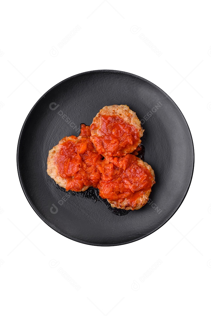 Deliciosas costeletas ou almôndegas frescas com especiarias, ervas e molho de tomate sobre um fundo escuro de concreto