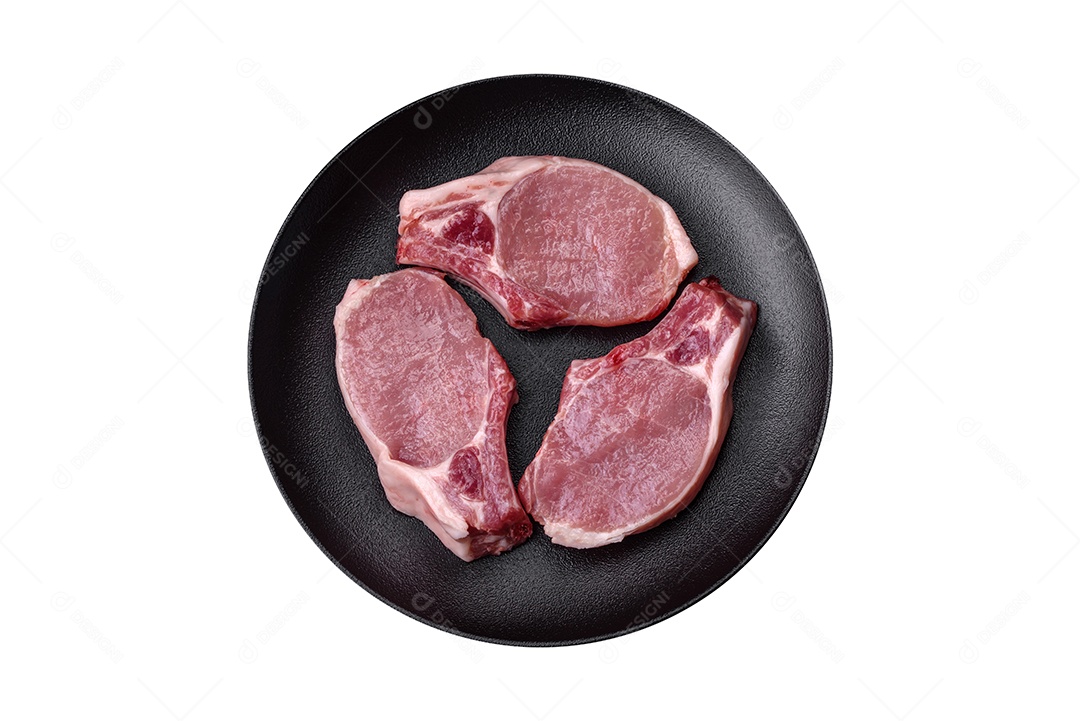 Bife fresco e cru com sal, especiarias e ervas em um fundo escuro e texturizado