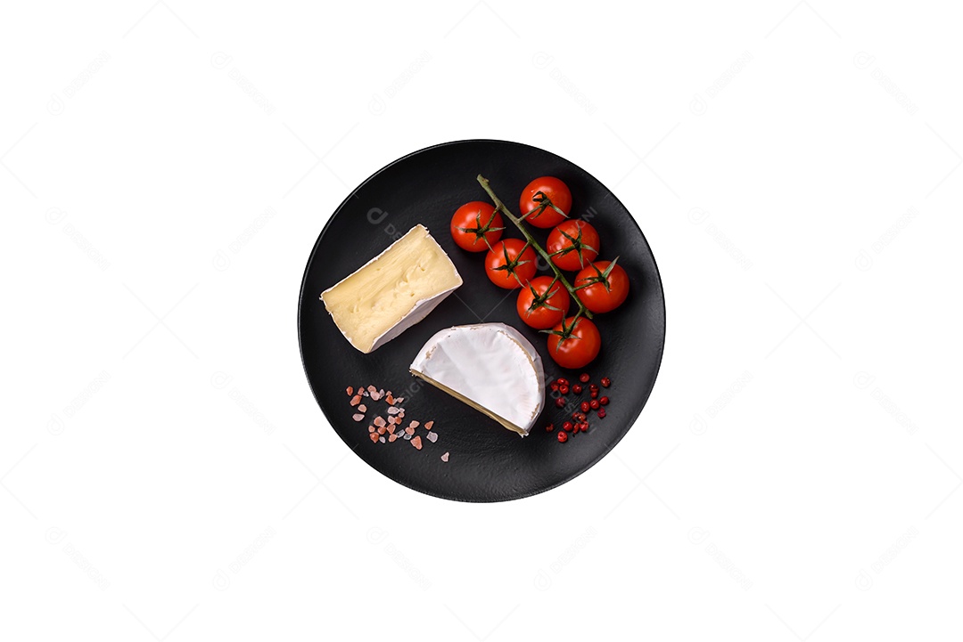 Delicioso queijo brie fresco em forma de mini cabeça com tomate cereja sobre fundo escuro de concreto