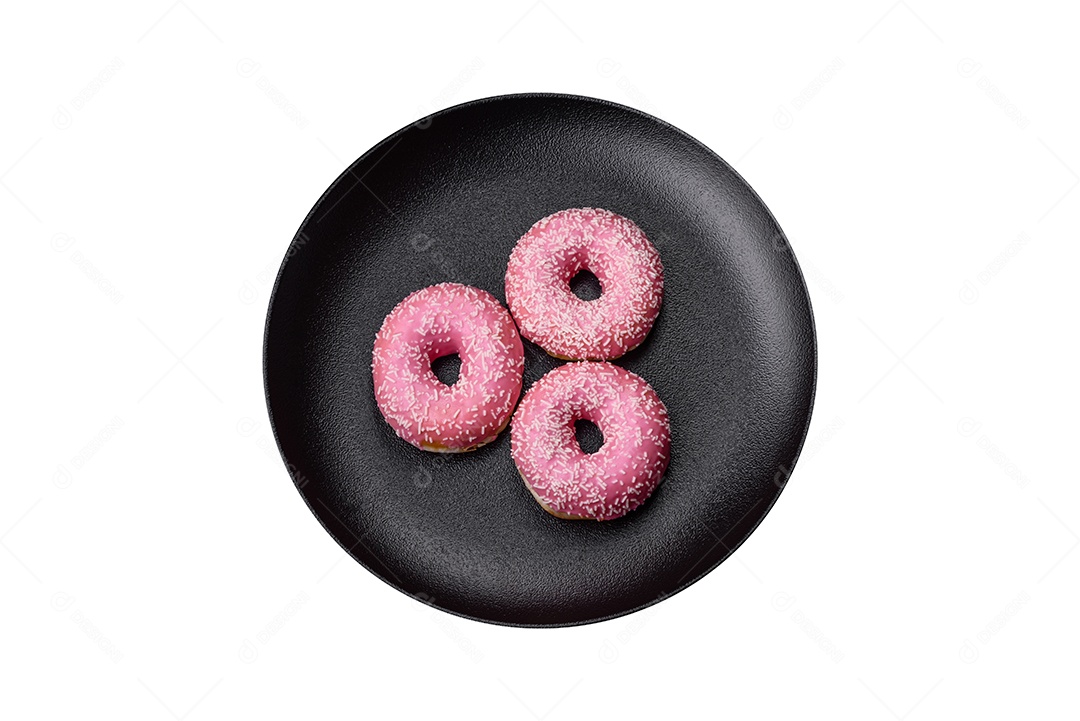 Deliciosos donuts doces frescos em esmalte rosa com recheio de morango sobre um fundo escuro de concreto