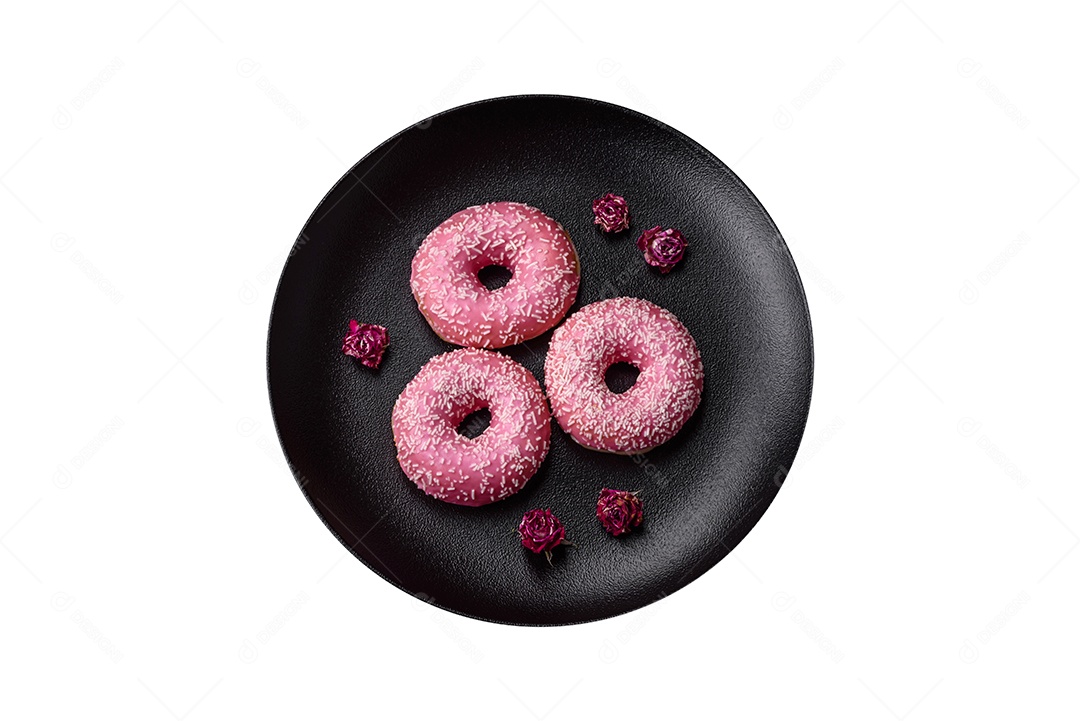 Deliciosos donuts doces frescos em esmalte rosa com recheio de morango sobre um fundo escuro de concret