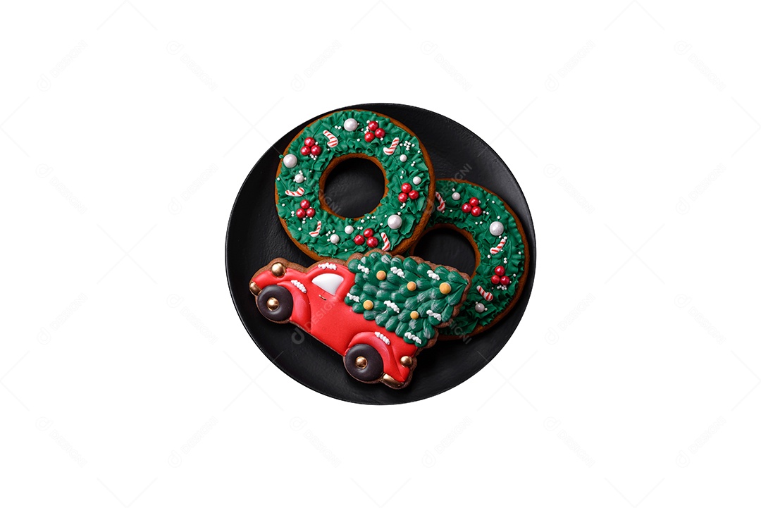 Lindos biscoitos de gengibre caseiros coloridos de Natal ou Ano Novo em uma placa cerâmica sobre um fundo escuro de concreto