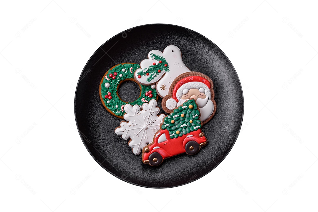 Lindos biscoitos de gengibre caseiros coloridos de Natal ou Ano Novo em uma placa cerâmica sobre um fundo escuro de concreto
