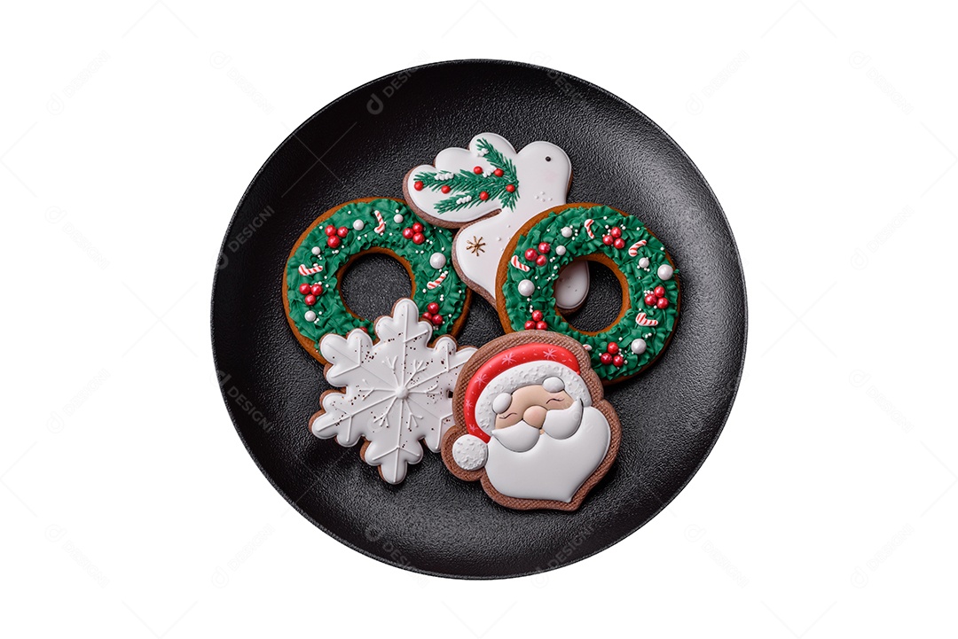 Lindos biscoitos de gengibre caseiros coloridos de Natal ou Ano Novo em uma placa cerâmica sobre um fundo escuro de concreto