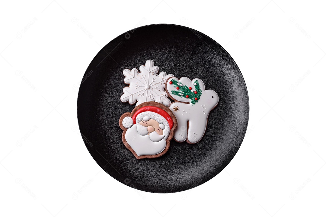 Lindos biscoitos de gengibre caseiros coloridos de Natal ou Ano Novo em uma placa cerâmica sobre um fundo escuro de concreto