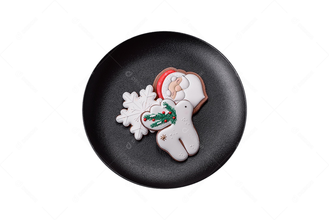 Lindos biscoitos de gengibre caseiros coloridos de Natal ou Ano Novo em uma placa cerâmica sobre um fundo escuro de concreto