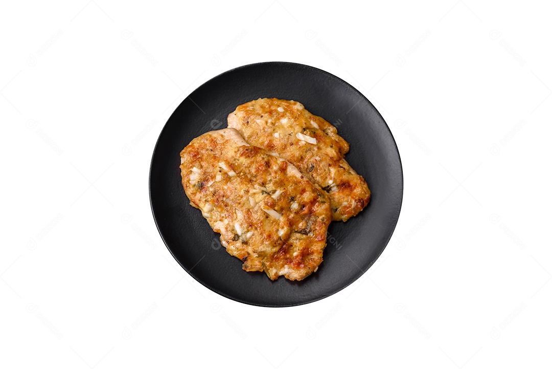 Deliciosas coxas de frango suculentas assadas com sal, especiarias e ervas em uma placa cerâmica sobre um fundo escuro de concreto