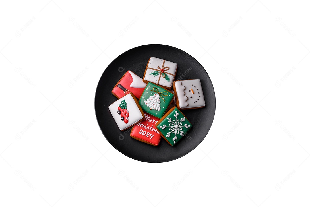 Lindos biscoitos de gengibre caseiros coloridos de Natal ou Ano Novo em uma placa cerâmica sobre um fundo escuro de concreto