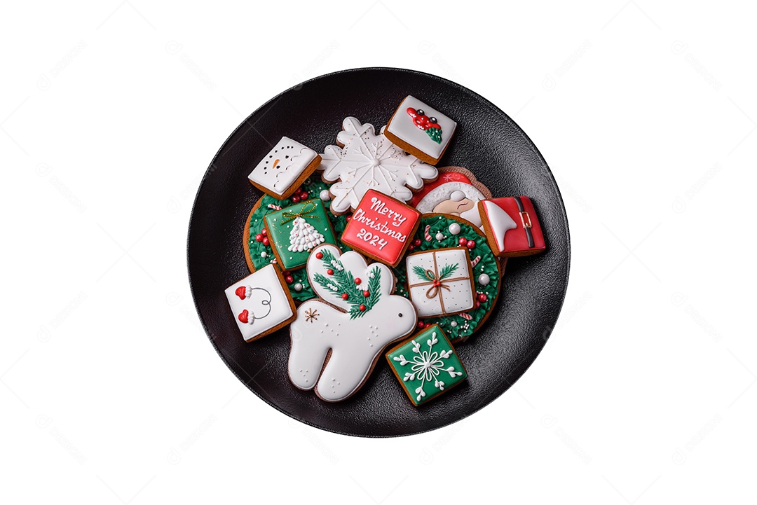 Lindos biscoitos de gengibre caseiros coloridos de Natal ou Ano Novo em uma placa cerâmica sobre um fundo escuro de concreto