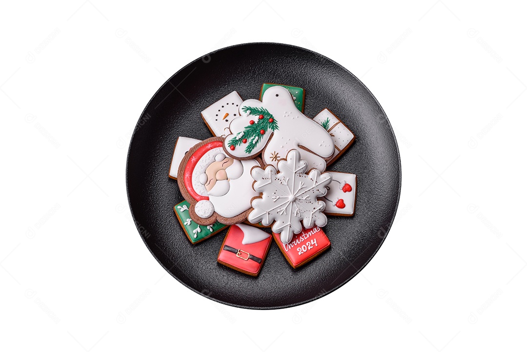 Lindos biscoitos de gengibre caseiros coloridos de Natal ou Ano Novo em uma placa cerâmica sobre um fundo escuro de concreto