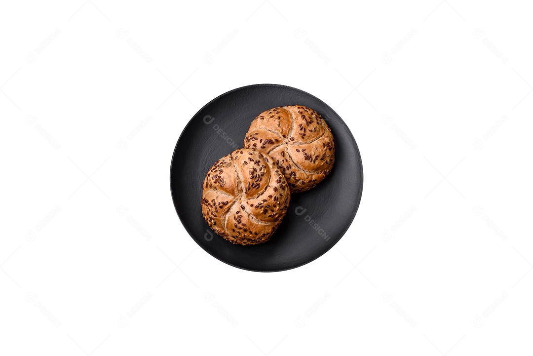 Delicioso pão crocante recém-assado ou rolo kaiser com sementes de gergelim em fundo escuro de concreto