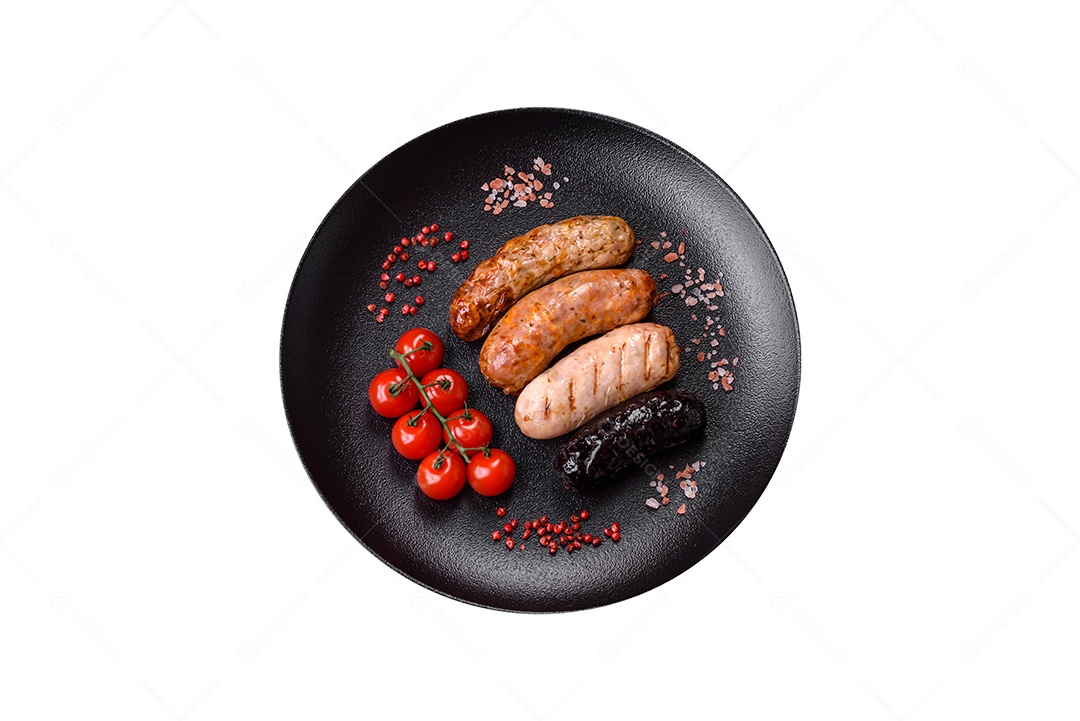Deliciosas salsichas grelhadas suculentas com sal, especiarias e ervas numa placa cerâmica sobre um fundo escuro de concreto