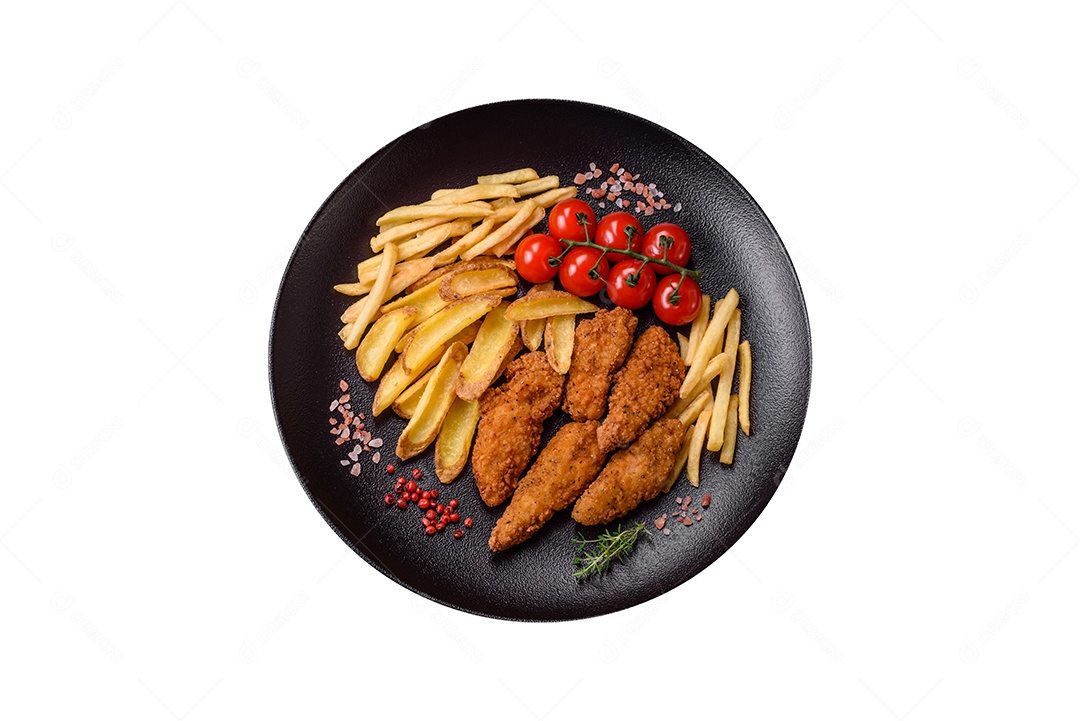 Deliciosos nuggets de frango crocantes à milanesa com sal e especiarias sobre um fundo escuro de concreto