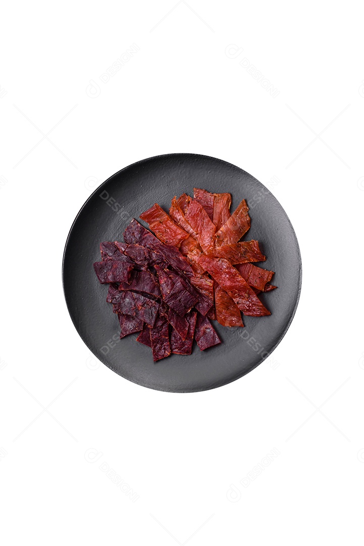 Deliciosa carne seca defumada ou carne seca de cavalo com especiarias e sal sobre um fundo escuro de concreto