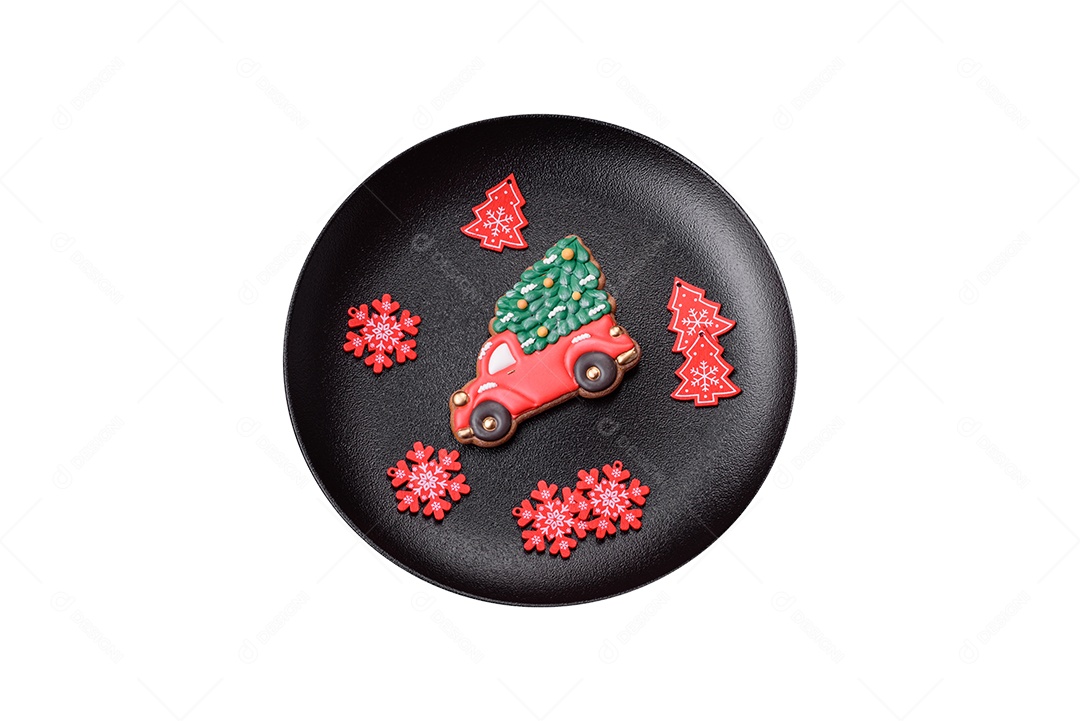 Lindos biscoitos de gengibre caseiros coloridos de Natal ou Ano Novo em uma placa cerâmica sobre um fundo escuro de concreto