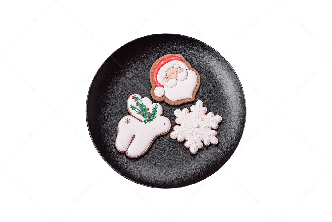 Lindos biscoitos de gengibre caseiros coloridos de Natal ou Ano Novo em uma placa cerâmica sobre um fundo escuro de concreto