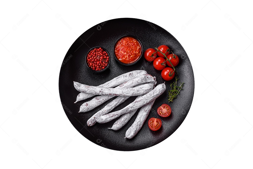 Delicioso fuet de linguiça defumada espanhola com sal e especiarias sobre um fundo escuro de concreto