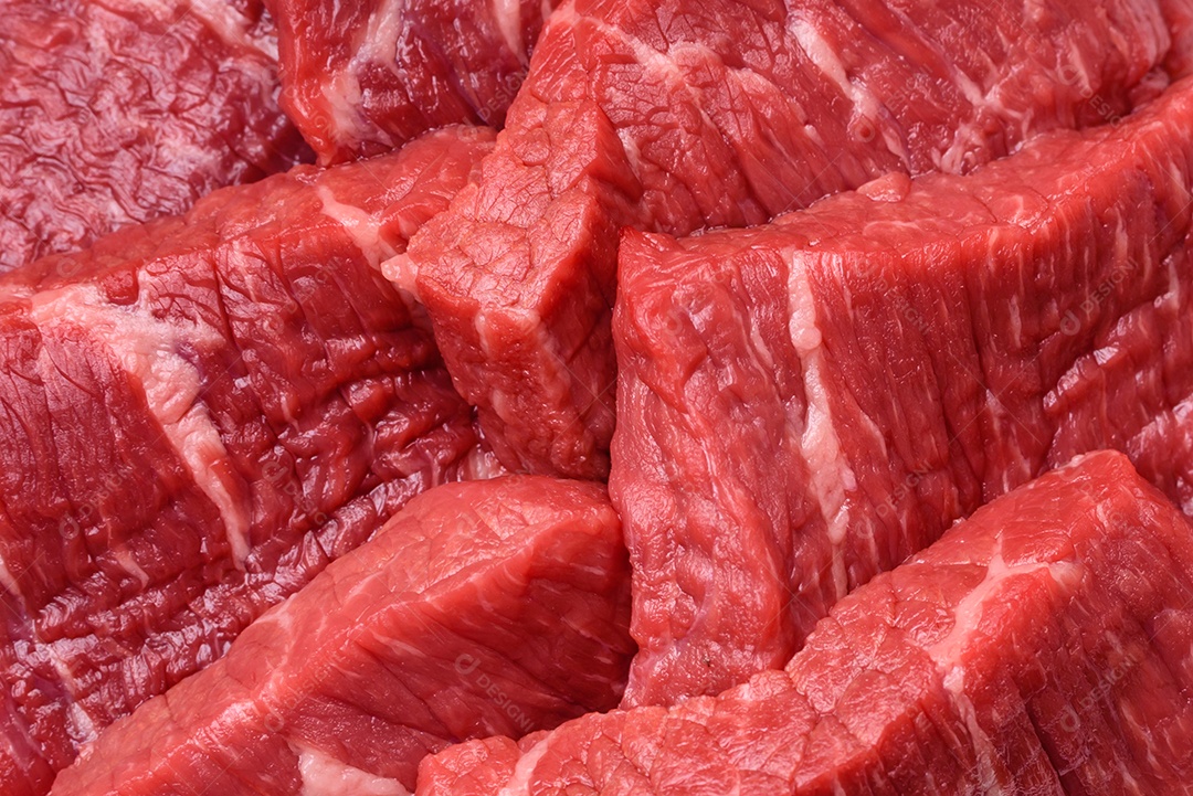 Fatias frescas e suculentas de carne crua com sal e especiarias sobre um fundo escuro de concreto