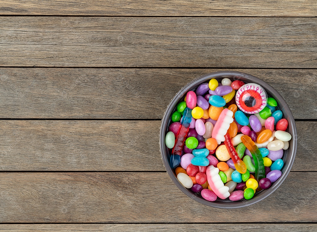 Doces coloridos sobre fundo laranja com espaço de cópia.