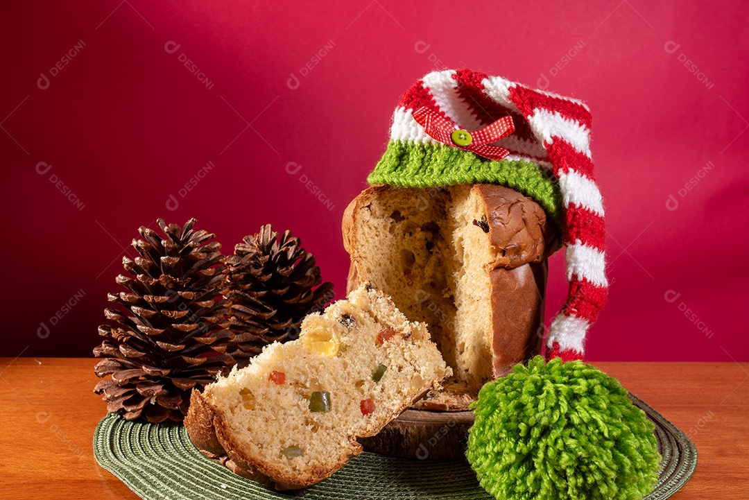 Panetone com chapéu de Papai Noel na mesa de madeira