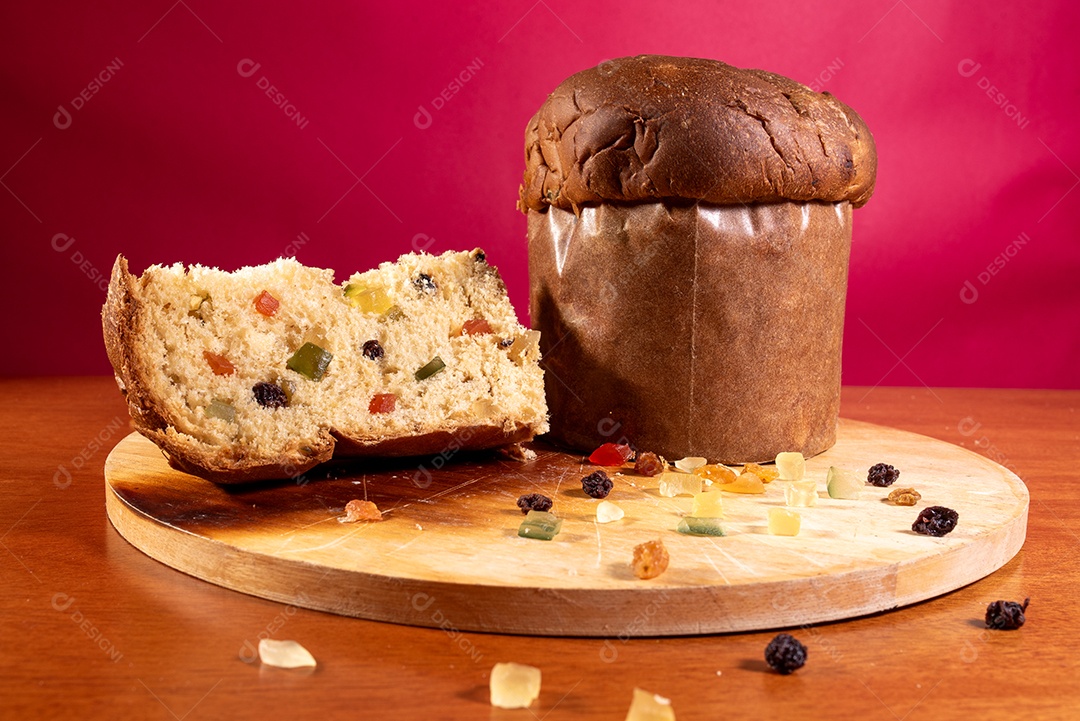 Panetone com frutas sobre tábua de madeira