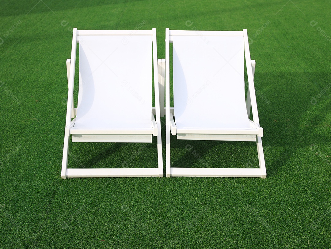 cadeira de lona de praia branca na grama verde